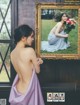 A woman in a purple dress holding a bouquet of flowers.