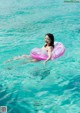 A woman floating on an inflatable ring in the ocean.