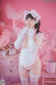 A woman in a pink and white lingerie posing for a picture.